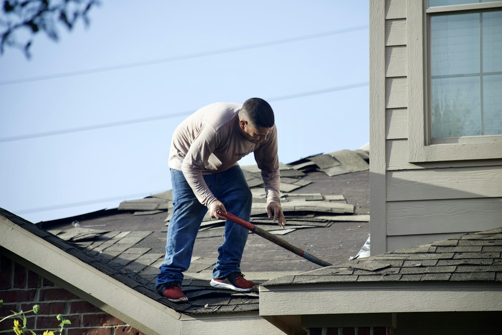 Roofer removing shingles from a residential roof